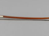 a close up of a metal and wood bow on a white surface