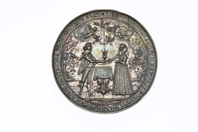 an image of a silver coin with a picture of a man and a woman