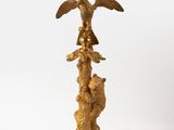 a gold lamp that has a bird on top of it