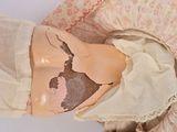 a close up of a doll with a hat on