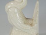 a white sculpture of a bird sitting on a book