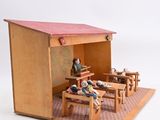 a small wooden model of a house with people sitting at tables