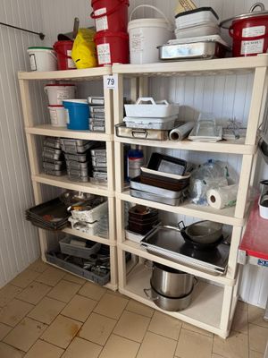 de nombreuses casseroles et poêles sur les étagères de la cuisine