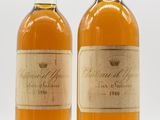 two bottles of wine sitting next to each other on a white surface