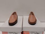 une paire de chaussures pour femme dans une boîte posée sur une surface blanche