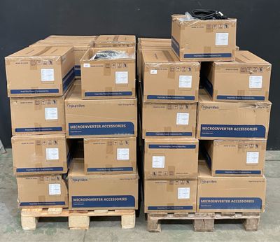 des cartons empilés sur des palettes devant un mur noir