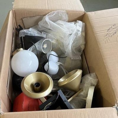 une boîte en carton remplie d'objets hétéroclites sur le sol
