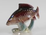 a glass figurine of a fish on a stand