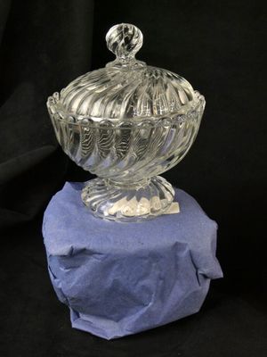 a glass bowl with a lid sitting on a rock