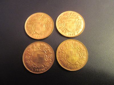 quatre types différents de pièces d'or sur une surface noire