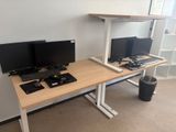 a desk with two monitors and a keyboard on it