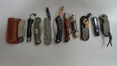 de nombreux modèles différents de couteaux de poche alignés sur une table
