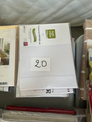 a pile of papers and a pair of scissors sitting on a bed