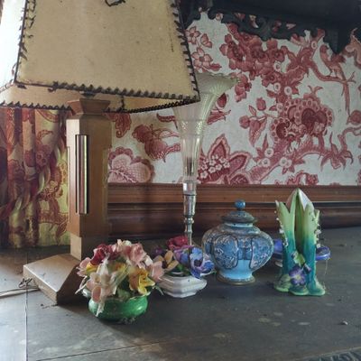 une lampe posée sur une table à côté d'un vase
