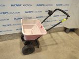 an image of a pink wheelbarrowd lawn cart