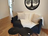 un salon avec un canapé, une table et un arbre accroché au mur