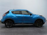 the blue nissan suv is parked in a room with a gray wall