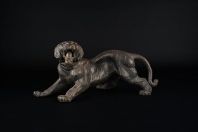 une statue en bronze représentant un chien sur fond noir