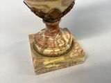 a vase that is sitting on a stand on a table