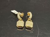 une paire de boucles d'oreilles dorées posées sur un fond noir