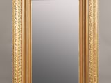 a gold framed mirror with a decorative design on the edge