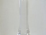 a clear glass vase sitting on a table next to a small vase
