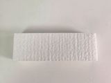 a piece of white paper on a white surface next to a toothbrush