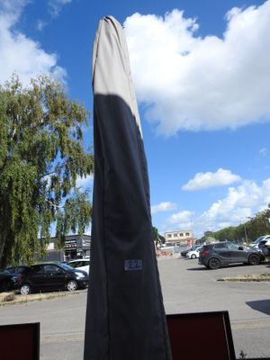 un grand parapluie posé au milieu d'un parking