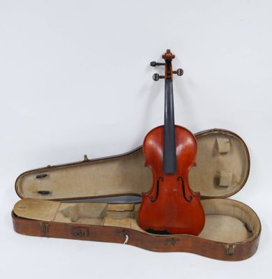 un vieux violon repose dans son étui, posé sur une surface blanche