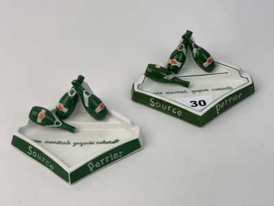 une paire de cendriers verts et blancs posés sur une table blanche