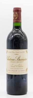 une vieille bouteille de vin posée sur une table blanche