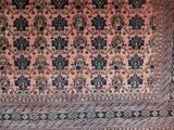 an antique persian rug with a blue border and a pink background