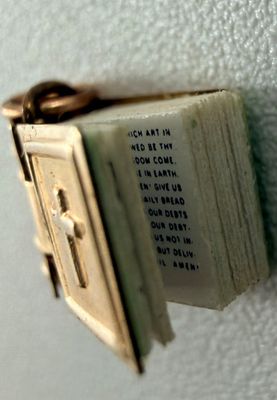 un petit livre orné d'une croix, accroché au mur