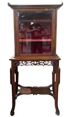 une vieille vitrine en bois surmontée d'une porte vitrée