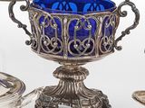un verre bleu posé à côté d'une assiette en argent