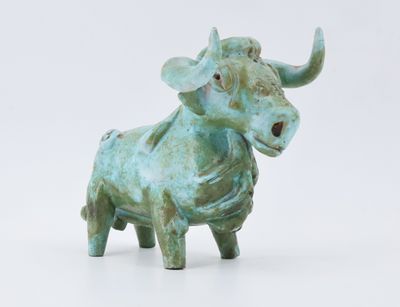 statue d'un taureau sur une surface blanche, avec un fond blanc