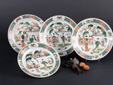 six assiettes chinoises et une petite figurine posées sur un fond noir