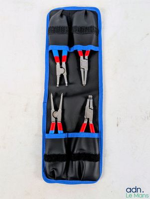 une paire de pinces dans un étui bleu posé sur une surface blanche