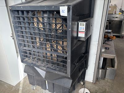 un climatiseur noir posé sur un chariot dans un garage