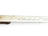 a close up of a knife with writing on it on a white surface