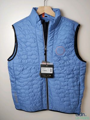 Le gilet est bleu et comporte un insigne.
