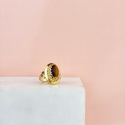 a close up of a gold ring sitting on top of a marble block