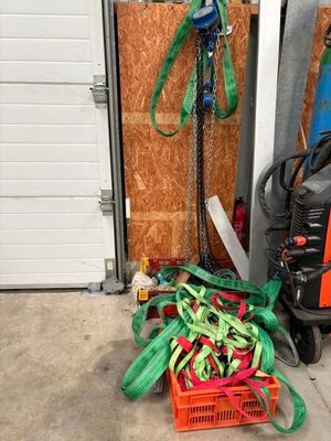 a pile of green and red hoses in front of a garage door