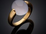 a close up of a gold ring with a white stone