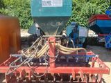 a close up of a tractor with a seeder attached to it