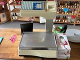 une photo d'une caisse enregistreuse posée sur une table dans un magasin