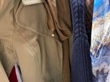 many coats and ties hanging on a rack in a store