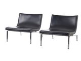une paire de fauteuils de salon en cuir noir avec des pieds chromés