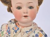 a small doll that is sitting on a white surface