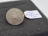 a close up of a silver brooch with a tag on it